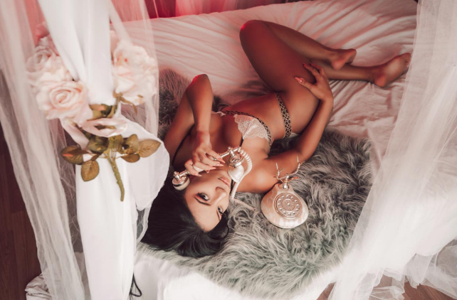 Woman in lingerie on bed holding vintage phone, creating a sensual and romantic atmosphere.