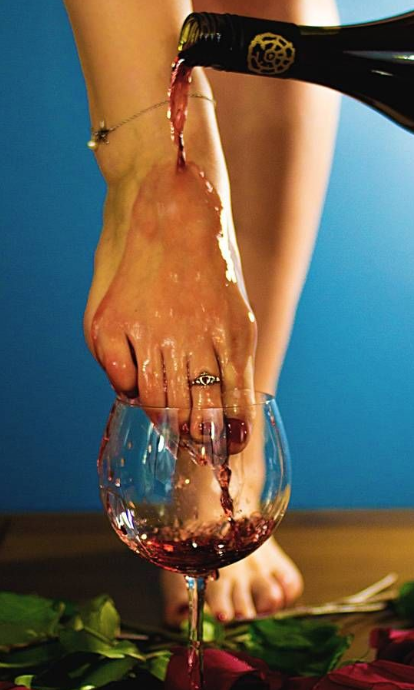 Feet pose featuring wine artistically pouring into a glass.